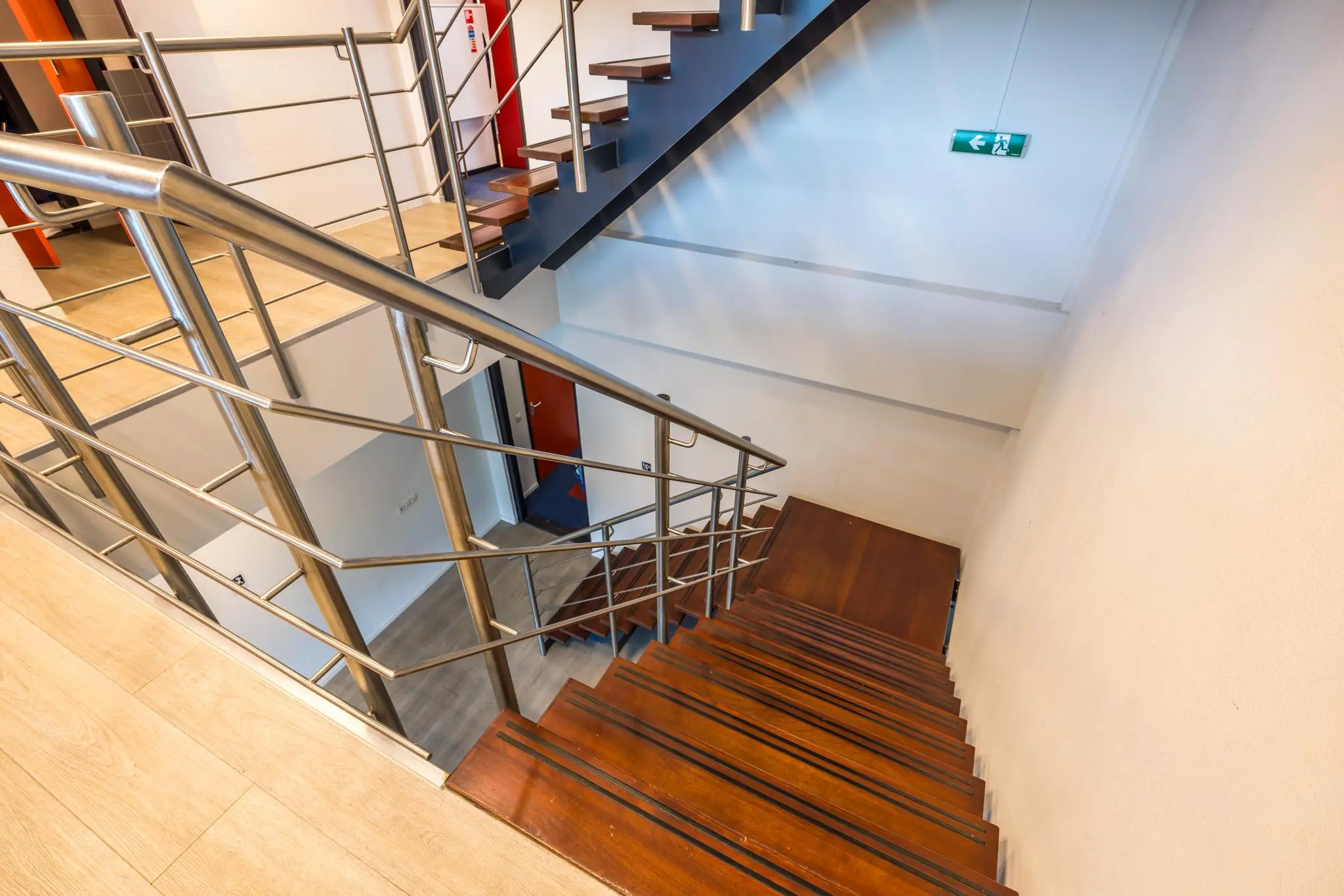 Trap met houten treden en metalen leuningen in een modern trappenhuis aan de Atoomweg.