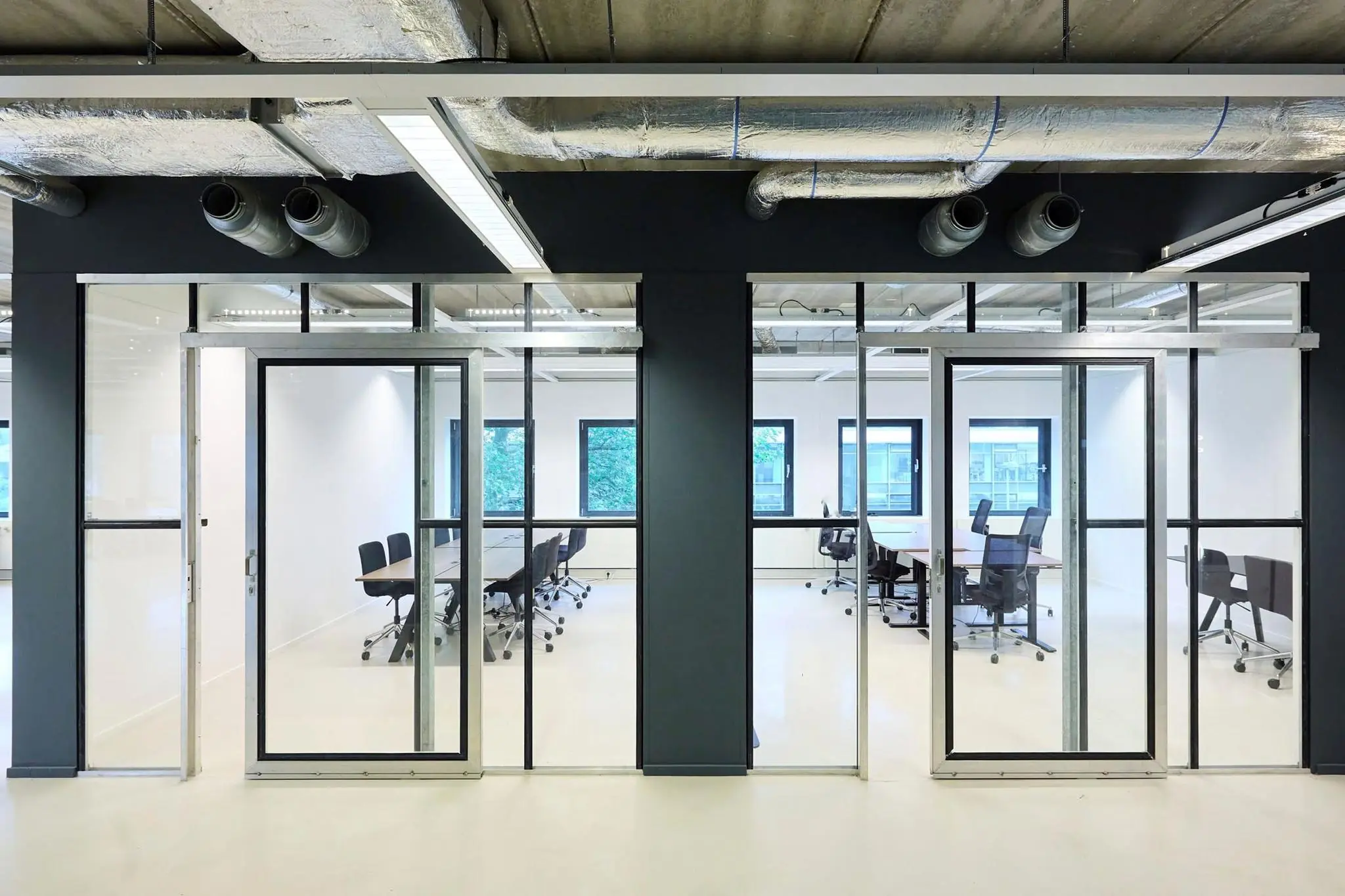 Moderne vergaderruimtes met glazen wanden in kantoorgebouw aan het John M. Keynesplein.