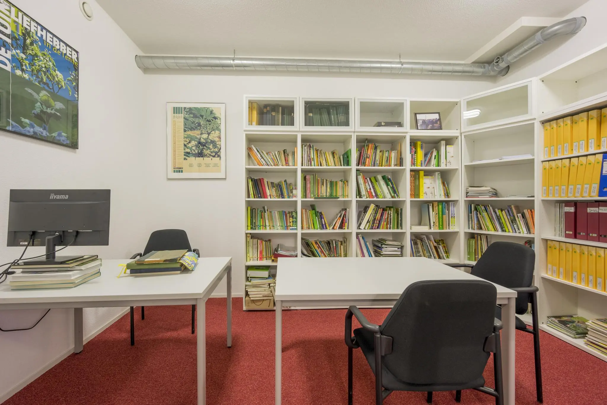 Kantoorruimte aan de Vogelvlinderweg met bureaus, boekenplanken en ordners in een nette, georganiseerde setting.