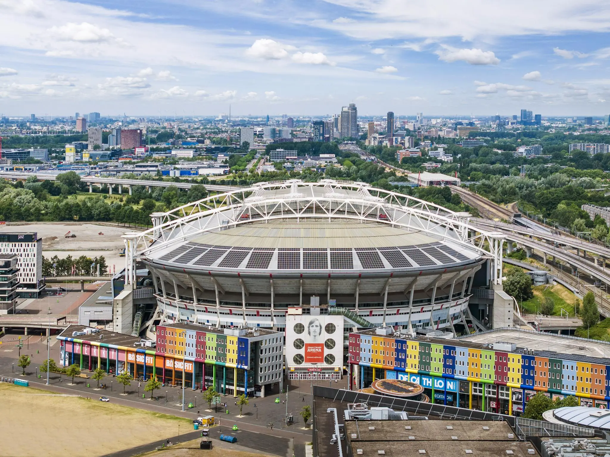 Luchtfoto van de Johan Cruijff ArenA in Amsterdam met omliggende gebouwen en stadsuitzicht.