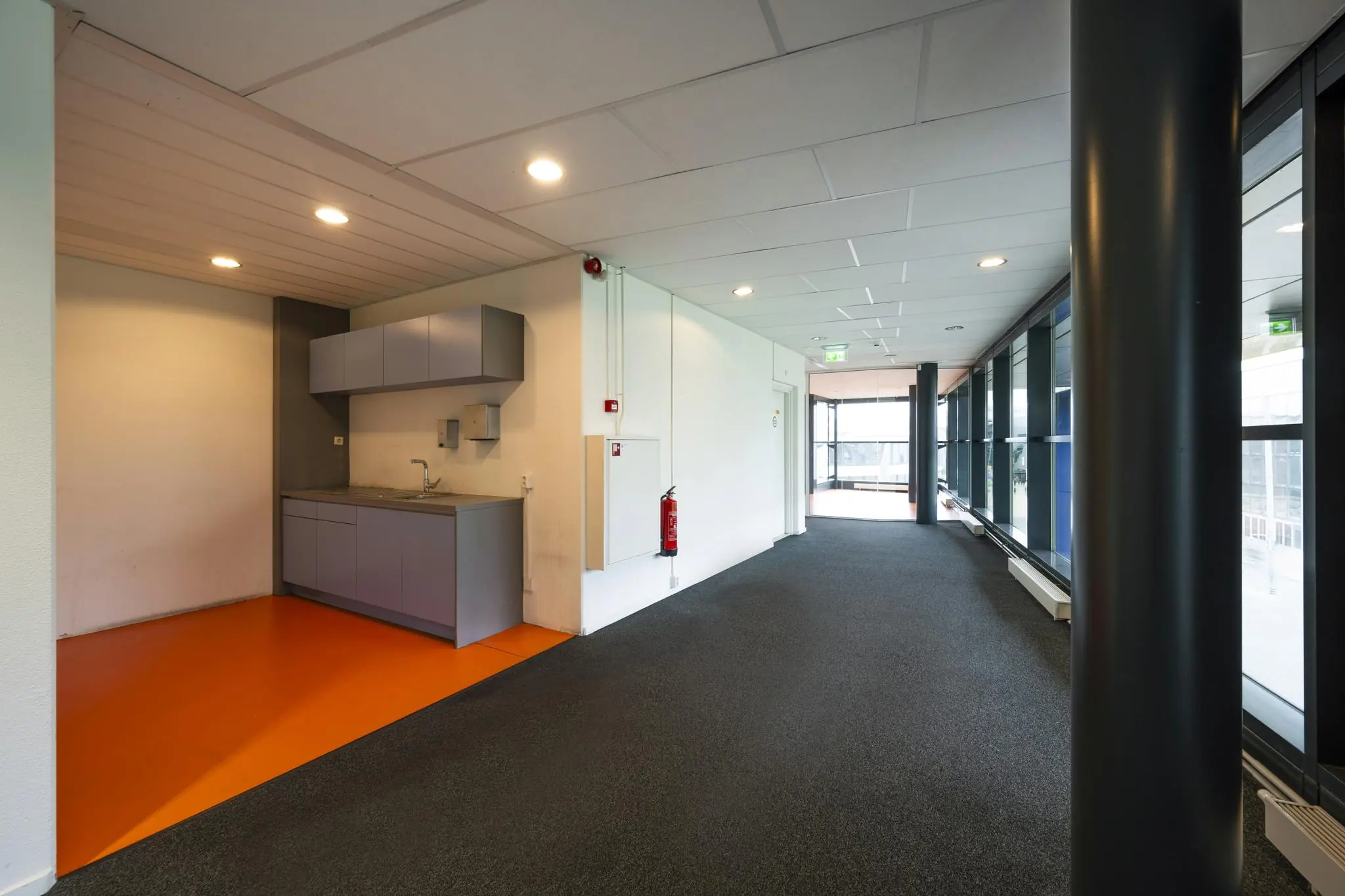 Verlichte gang op de Johan Cruijff Boulevard met een kleine pantry met oranje vloer.