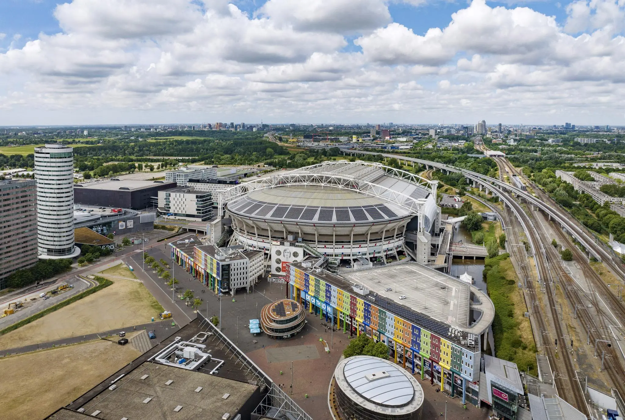 Luchtfoto van de Johan Cruijff ArenA en de omliggende gebouwen aan de Johan Cruijff Boulevard in Amsterdam.