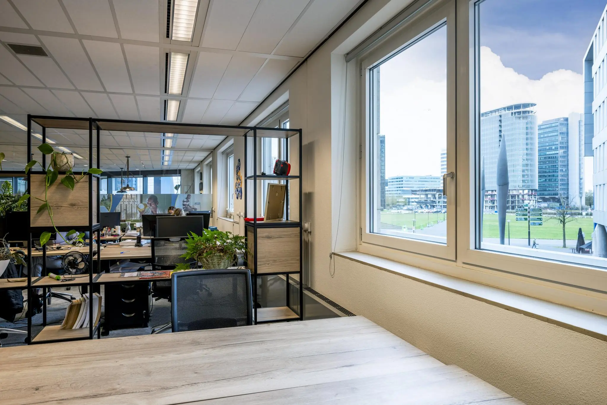 Kantoorruimte met uitzicht op de Johan Cruijff Boulevard en moderne kantoorgebouwen in Amsterdam.