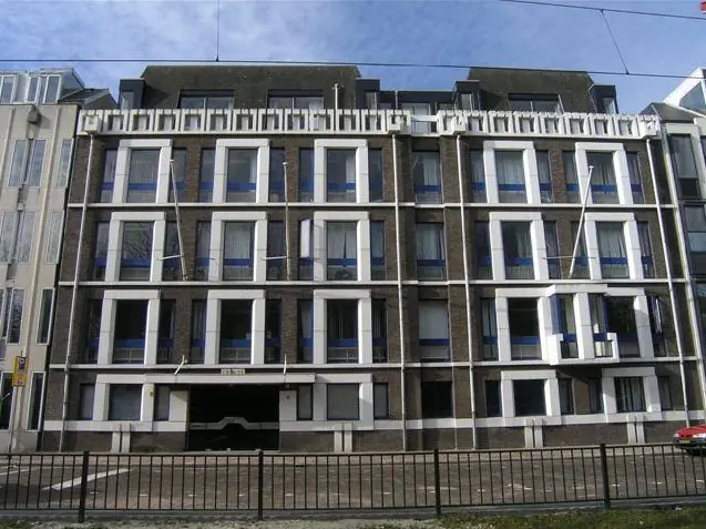 Vooraanzicht van een modern kantoorgebouw aan de Koninginnegracht in Den Haag met symmetrische ramen en witte accenten.