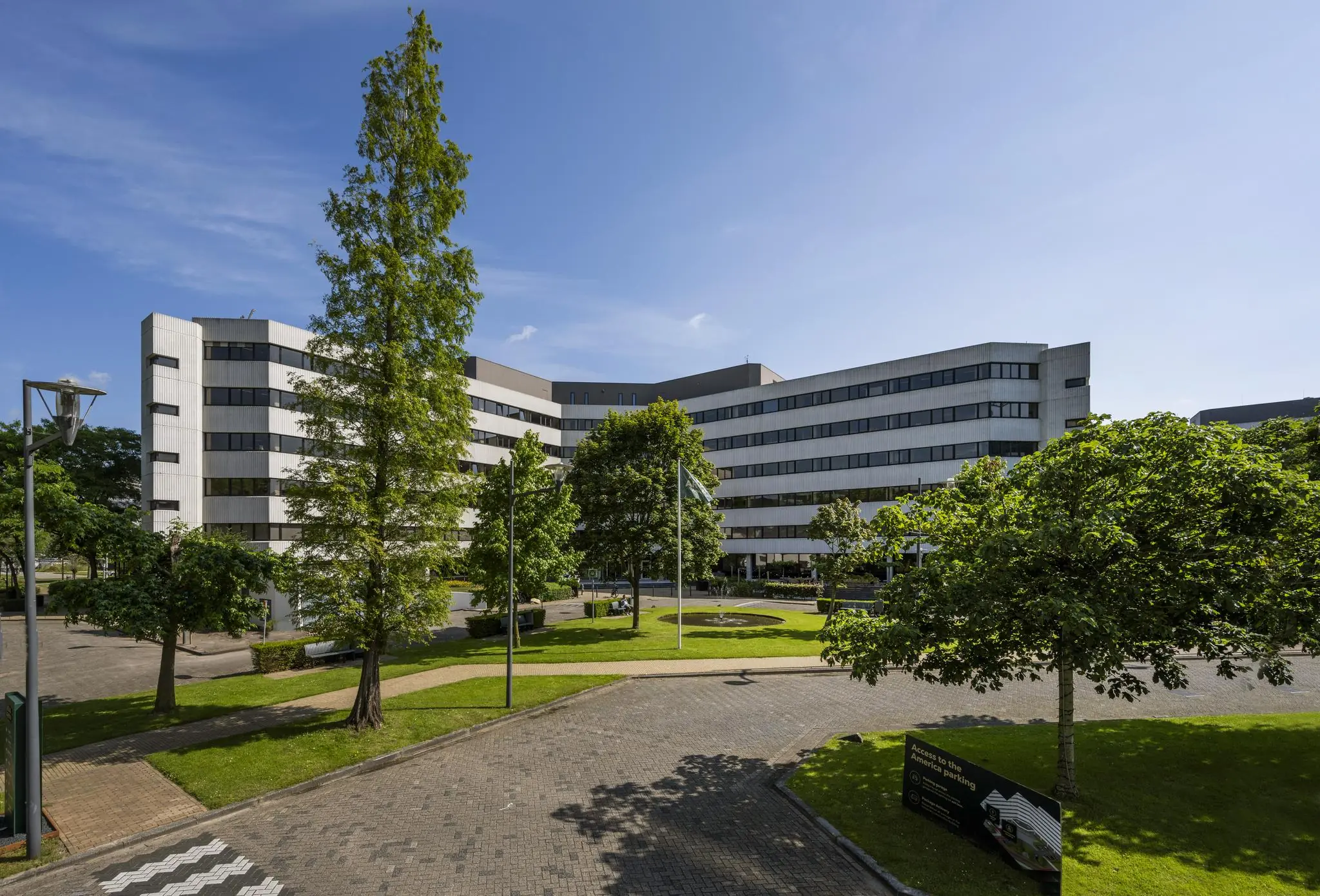 Modern kantoorgebouw aan de Hoogoorddreef in Amsterdam Zuidoost, omringd door groen en een verzorgde bestrating.