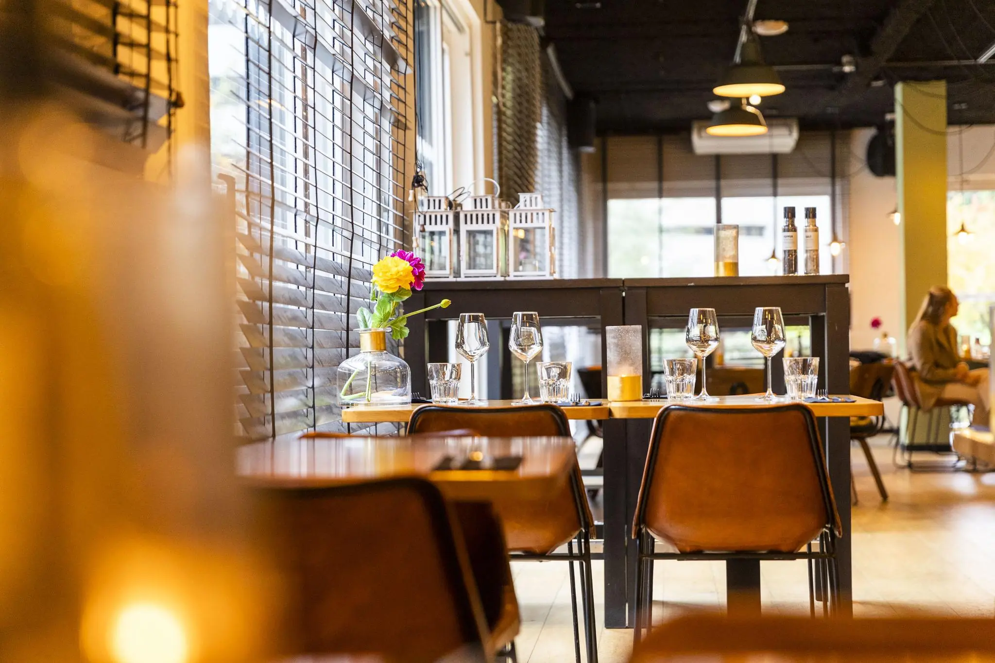 Modern ingericht restaurant aan de Hoogoorddreef met sfeervol gedekte tafels en warme verlichting.