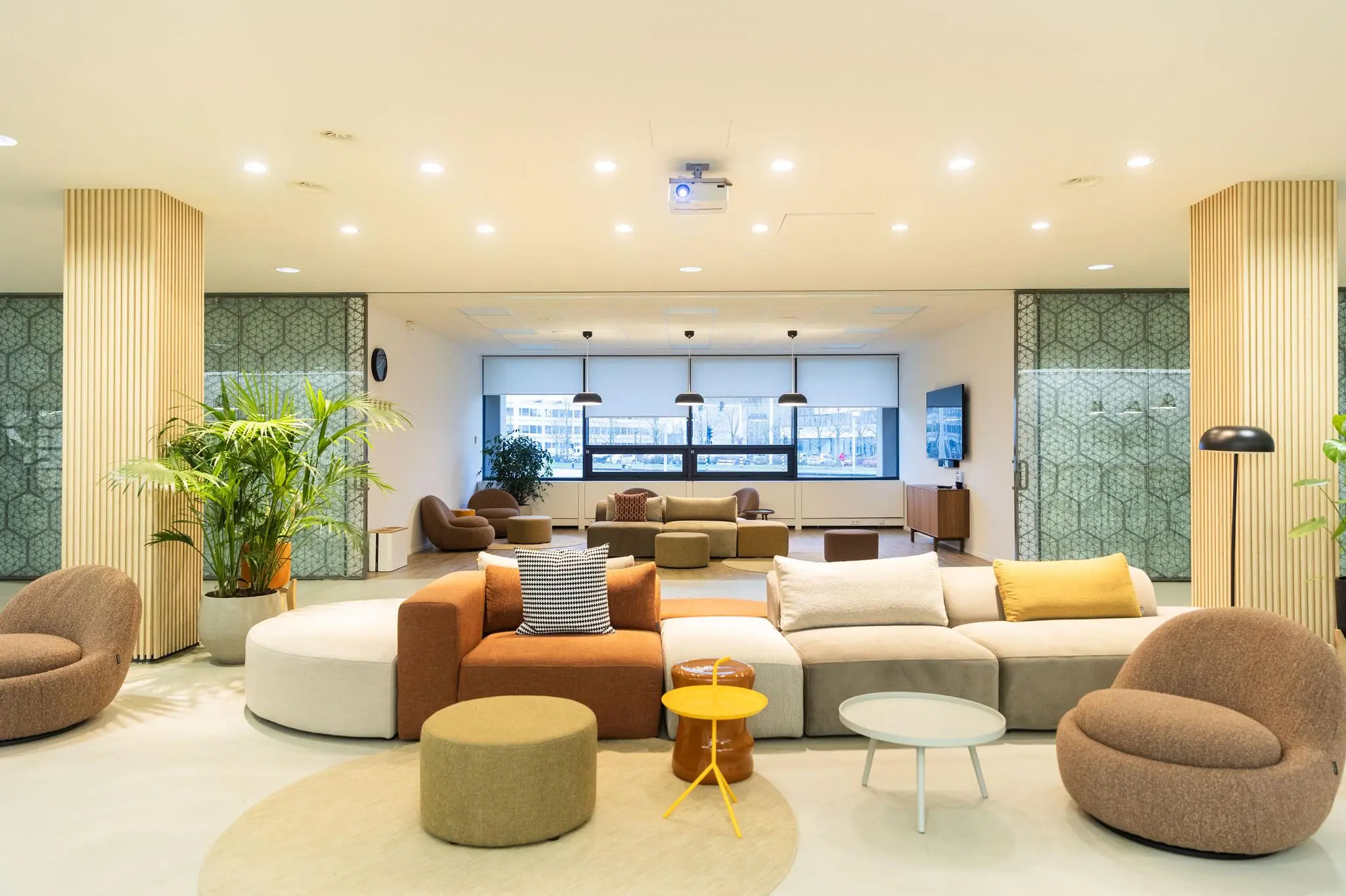 Modern ingerichte lounge in een kantoorpand aan de Hoogoorddreef met comfortabele zitmeubels, planten en grote ramen.