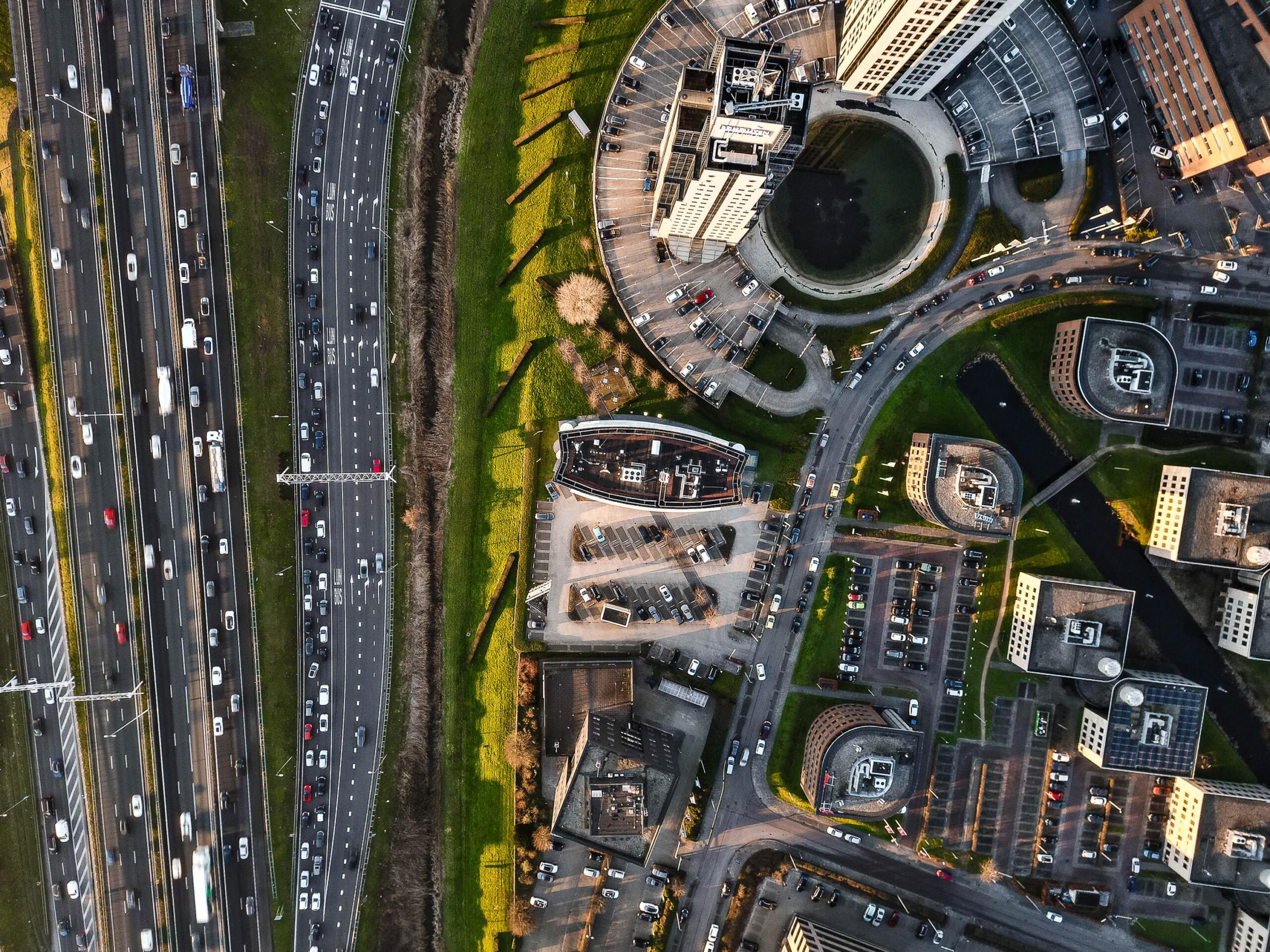 Luchtfoto van het Rivium Quadrant met druk verkeer op de snelweg en omringende kantoren en parkeerplaatsen.