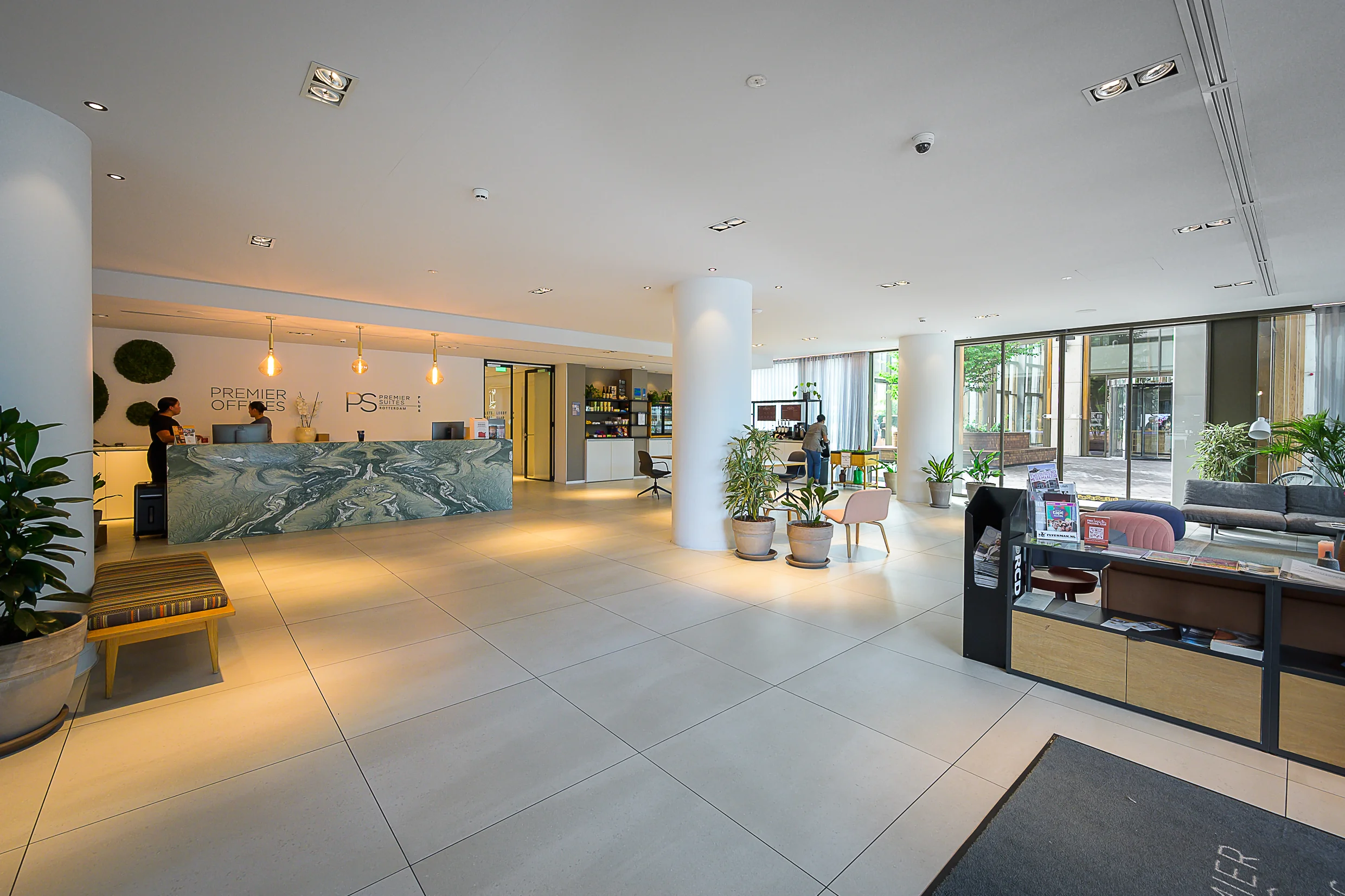 Modern reception area at Premier Offices Weena with a marble desk, seating area, and large glass windows.