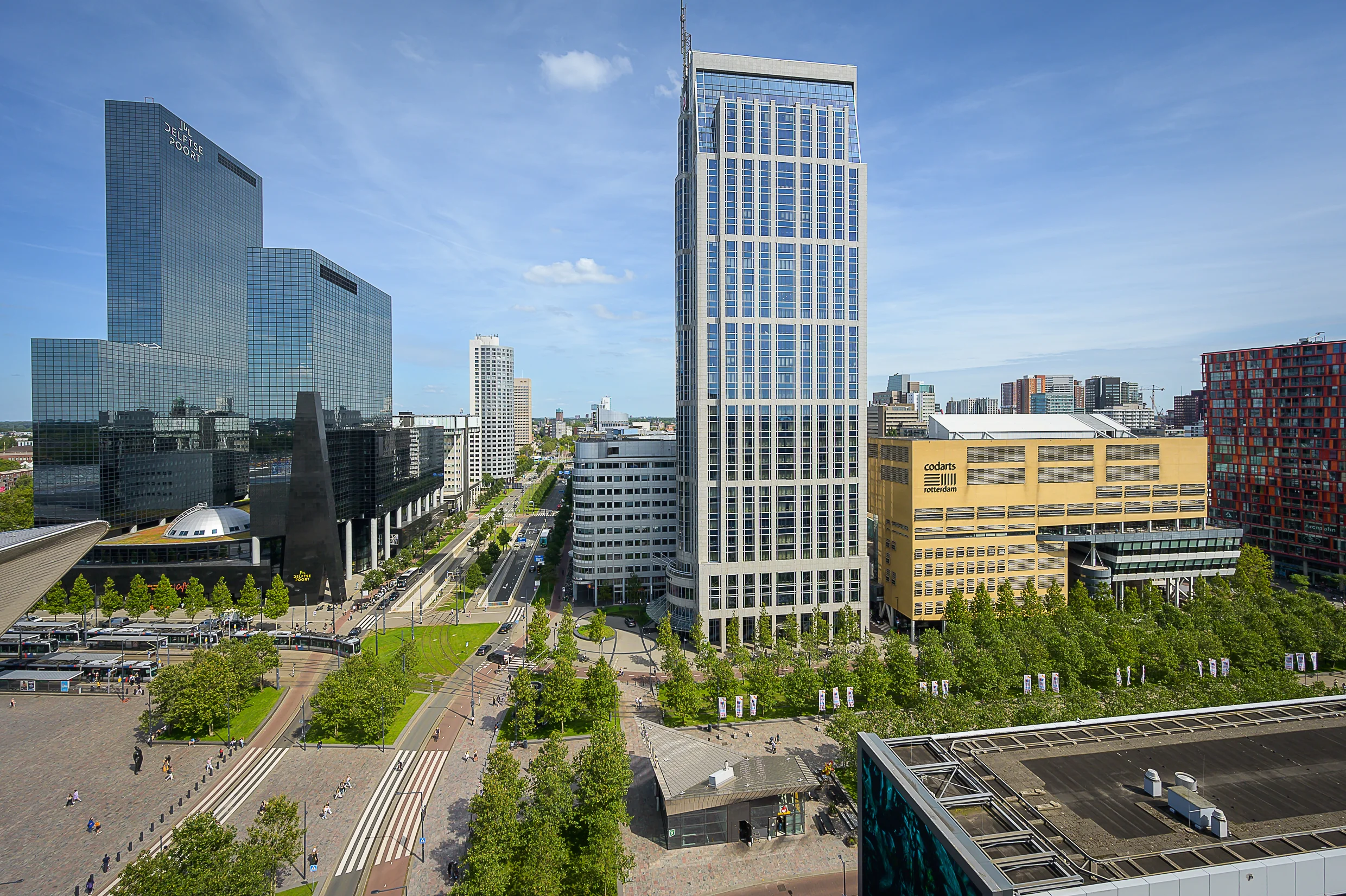 A cityscape view of Weena in Rotterdam featuring modern high-rise buildings, including the Delftse Poort and the Codarts Rotterdam building.
