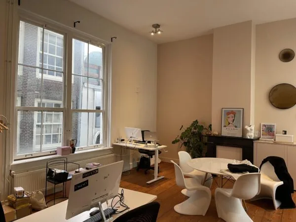 Modern ingerichte kantoorruimte aan de Singel met grote ramen, werkplekken en een ronde vergadertafel.