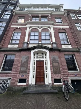 Voorgevel van een historisch pand aan de Singel in Amsterdam met huisnummer 512 en een fiets voor de deur.