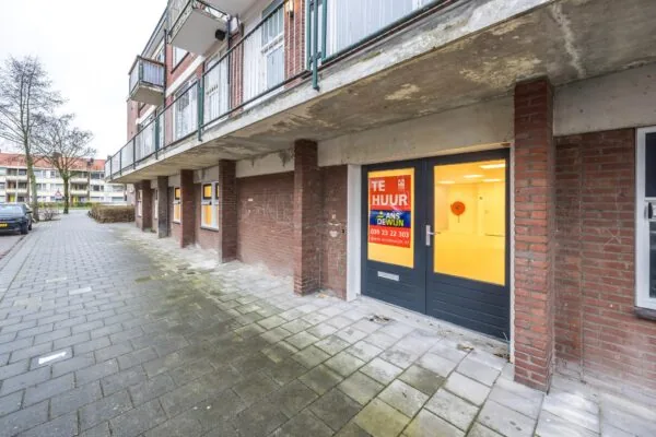 Winkel- of kantoorruimte aan de Wallesteinlaan met 'Te Huur'-poster van Ans de Wijn in het raam.