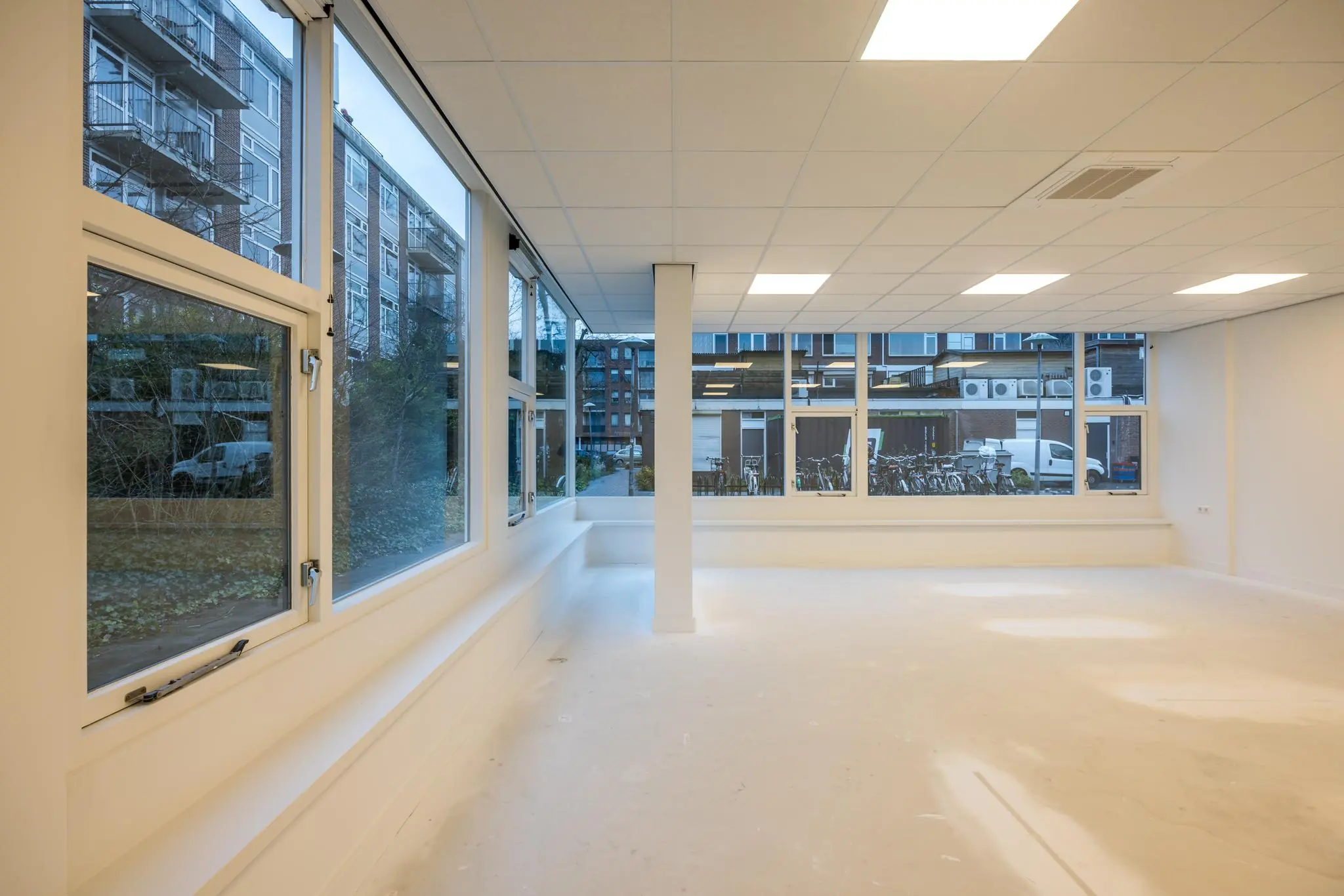 Leeg en licht kantoor- of bedrijfsruimte aan de Wallesteinlaan met grote ramen en systeemplafond.