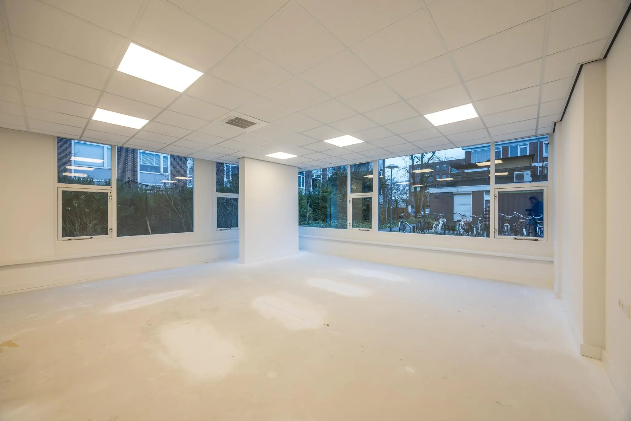 Leeg en licht kantoorruimte met grote ramen aan de Wallesteinlaan.