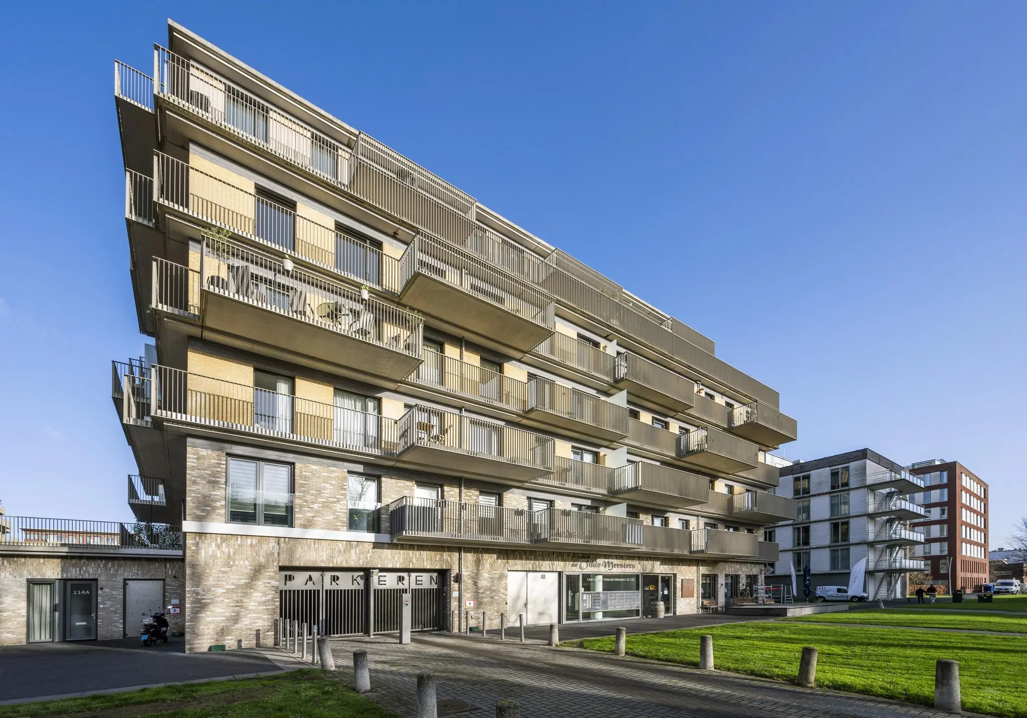 Modern appartementsgebouw aan de Laan van de Helende Meesters met uitkragende balkons en een parkeergarage op de begane grond.