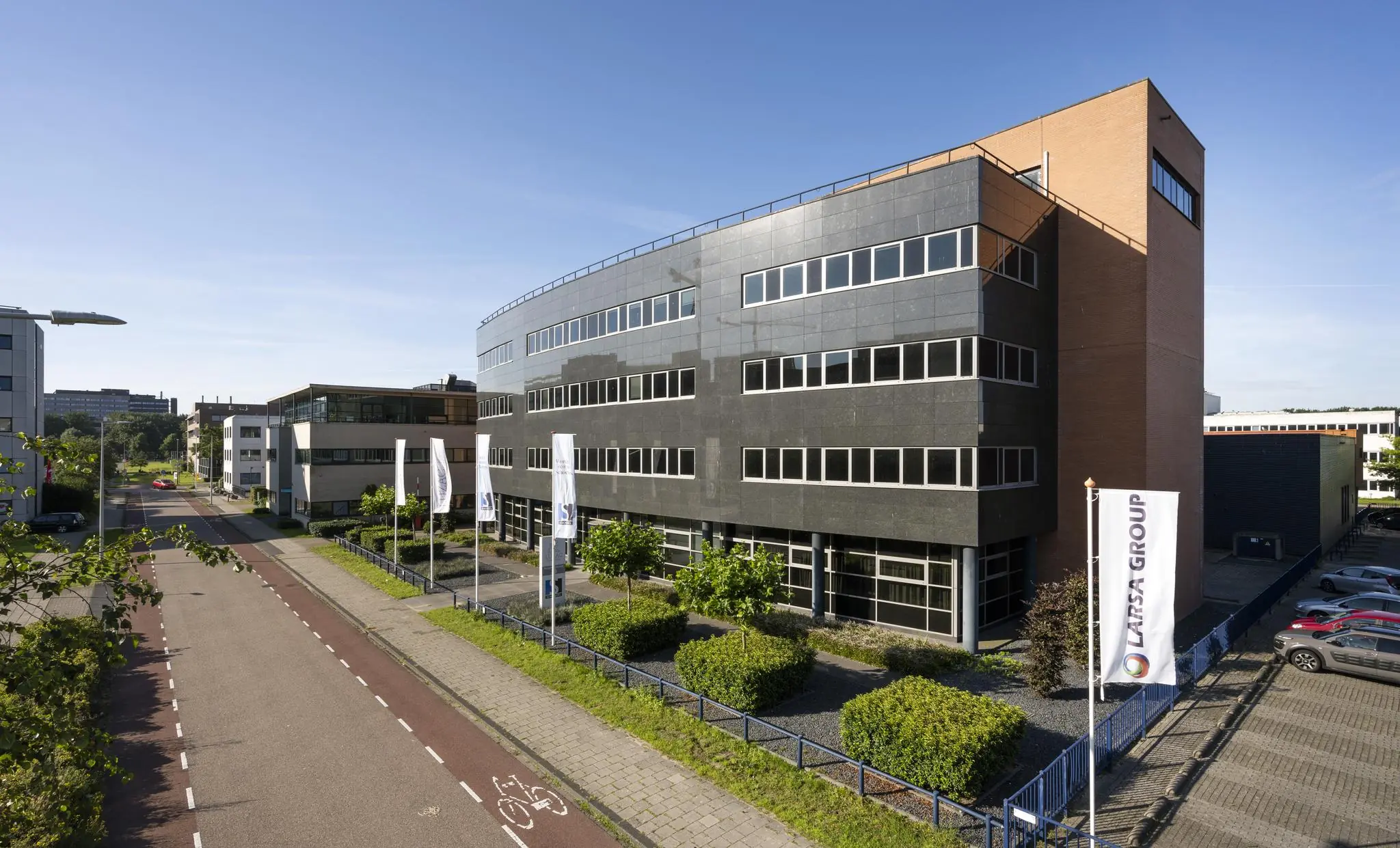 Modern kantoorgebouw aan de Paasheuvelweg in Amsterdam met vlaggen van Latsa Group voor de gevel.
