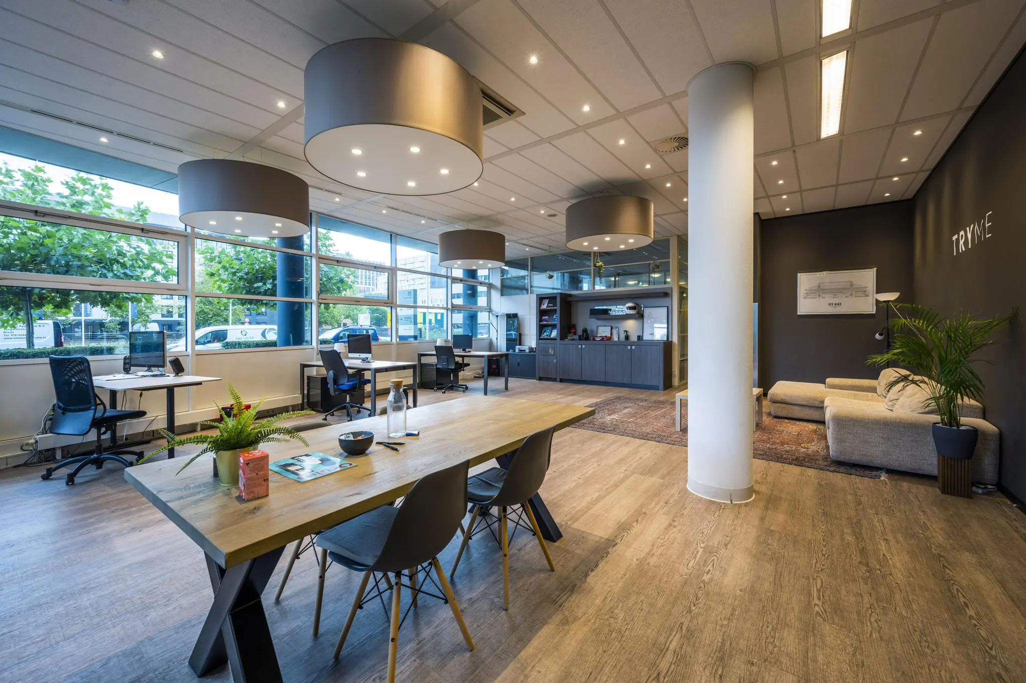 Modern kantoorinterieur aan de Paasheuvelweg met open werkplekken, vergadertafel en loungehoek.