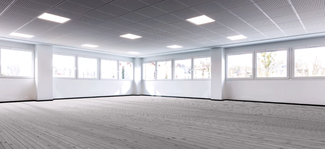 Lichte, lege ruimte met grote ramen en een houten vloer in het gebouw aan de Zonnebaan.