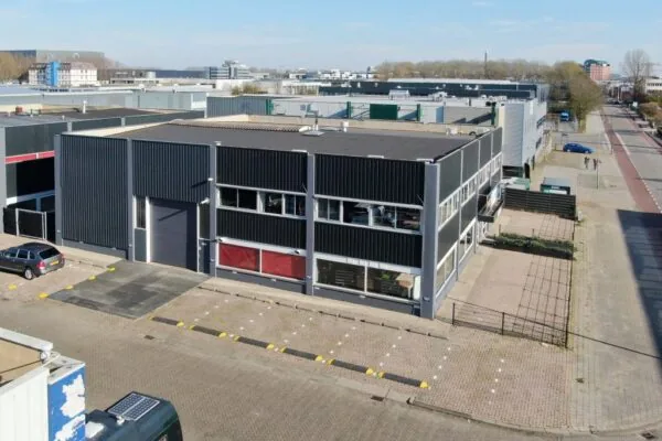 Bedrijfsgebouw aan de Zonnebaan op een bedrijventerrein met parkeerplaatsen en omliggende industriële panden.