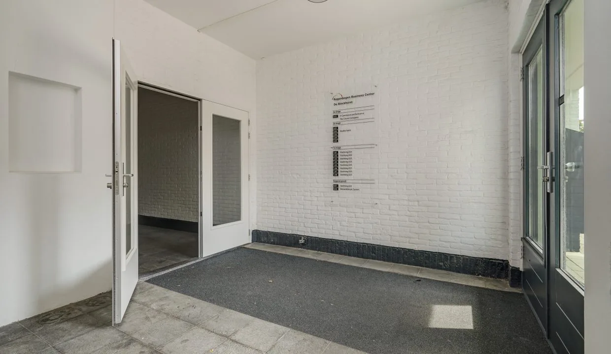 Entreehal van het bedrijfsverzamelgebouw aan de Mercuriusweg met witte muren, glazen deuren en een overzichtsbord met bedrijfsnamen.