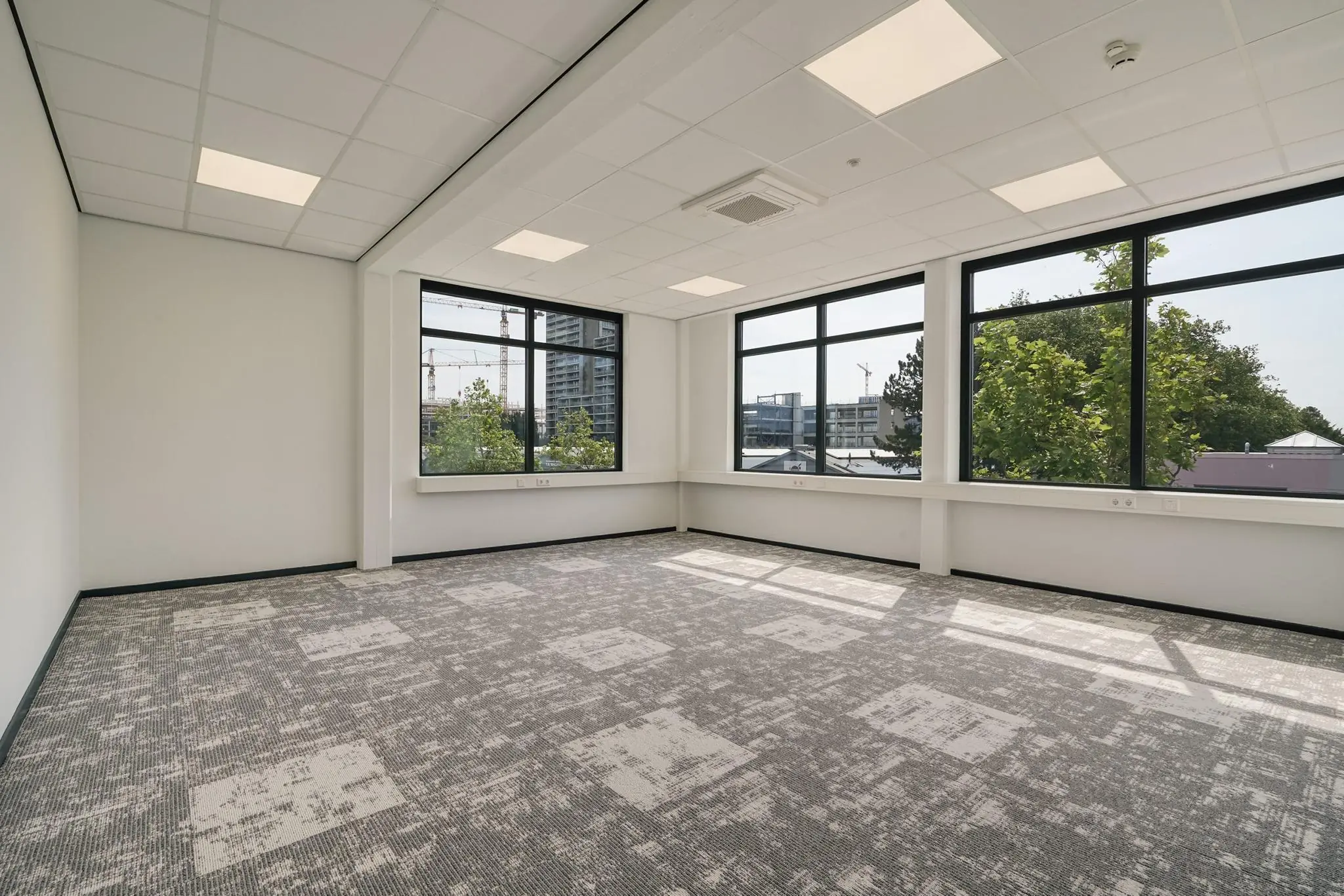 Licht en modern leeg kantoor aan de Mercuriusweg met grote ramen en uitzicht op stad en groen.