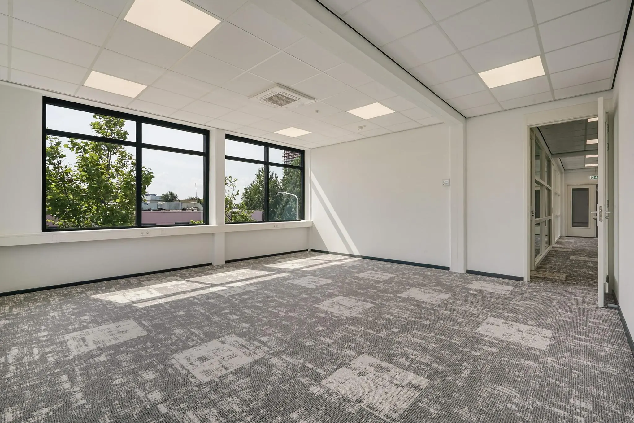 Licht en modern leeg kantoorpand aan de Mercuriusweg met grote ramen en systeemplafond.