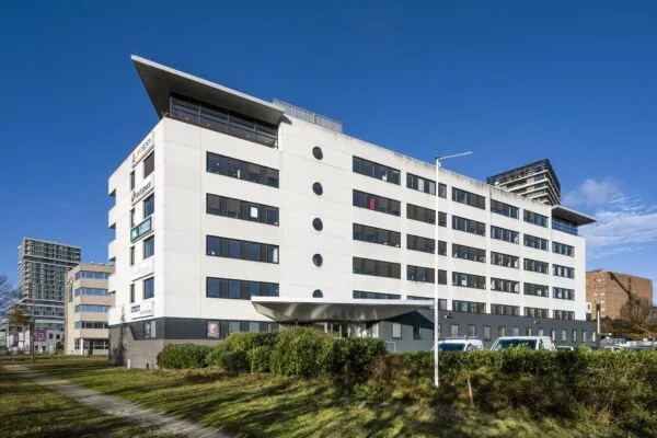 Wit kantoorgebouw aan de Radarweg in Amsterdam met meerdere bedrijfslogo’s op de gevel.