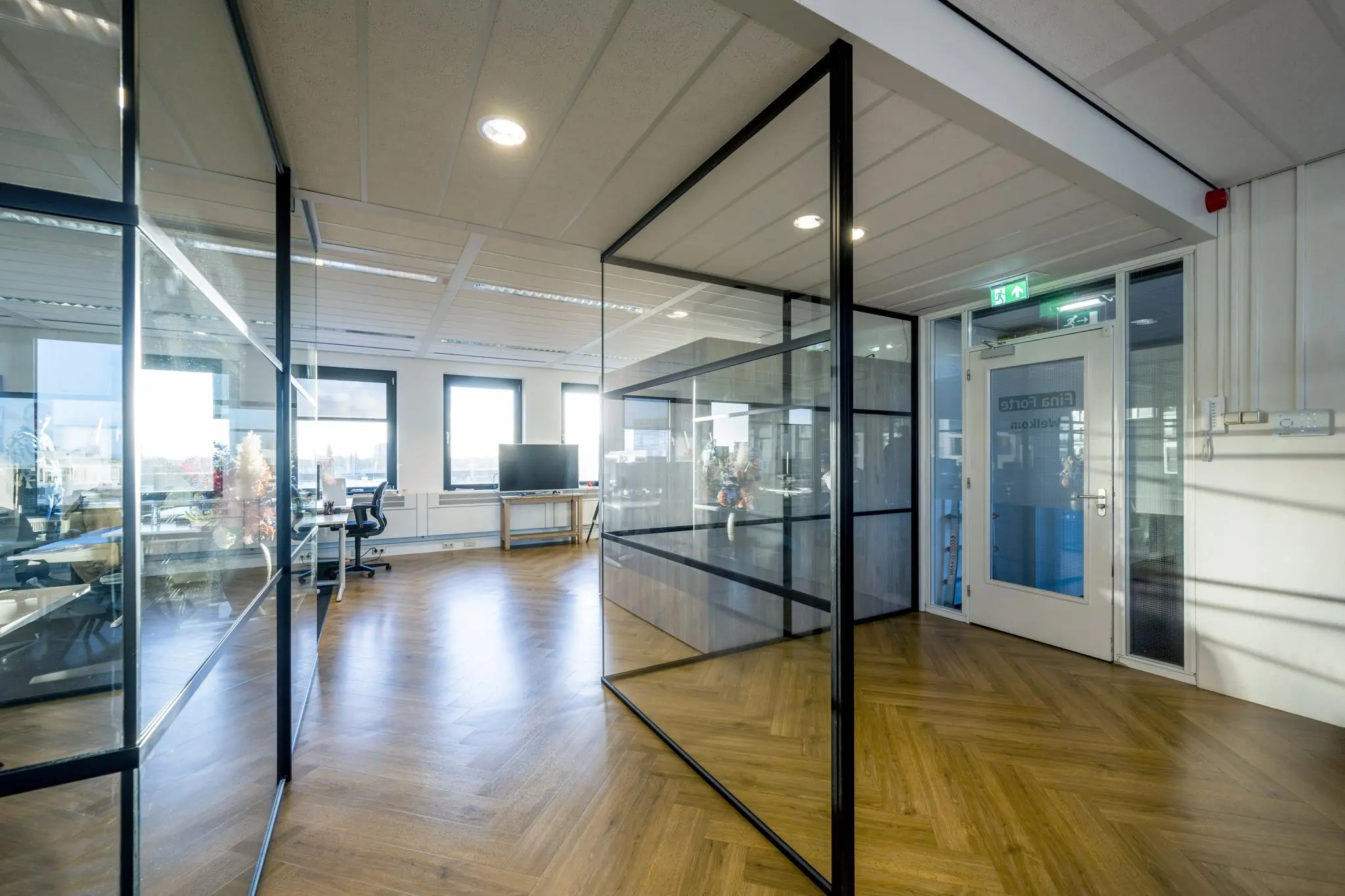 Moderne kantoorruimte op Radarweg met glazen wanden, houten visgraatvloer en veel natuurlijk licht.