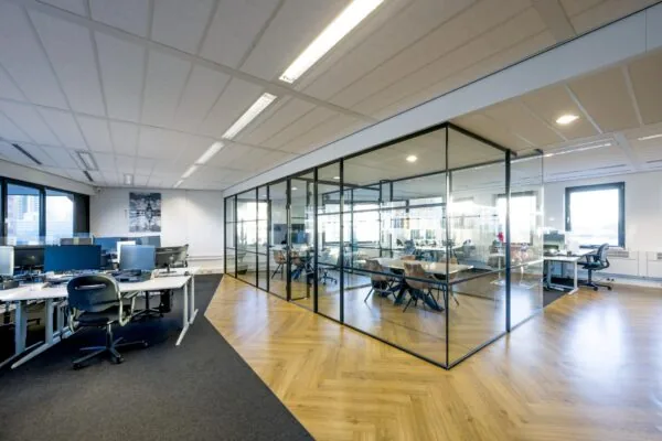 Moderne kantoorruimte aan de Radarweg met open werkplekken en een vergaderruimte met glazen wanden.