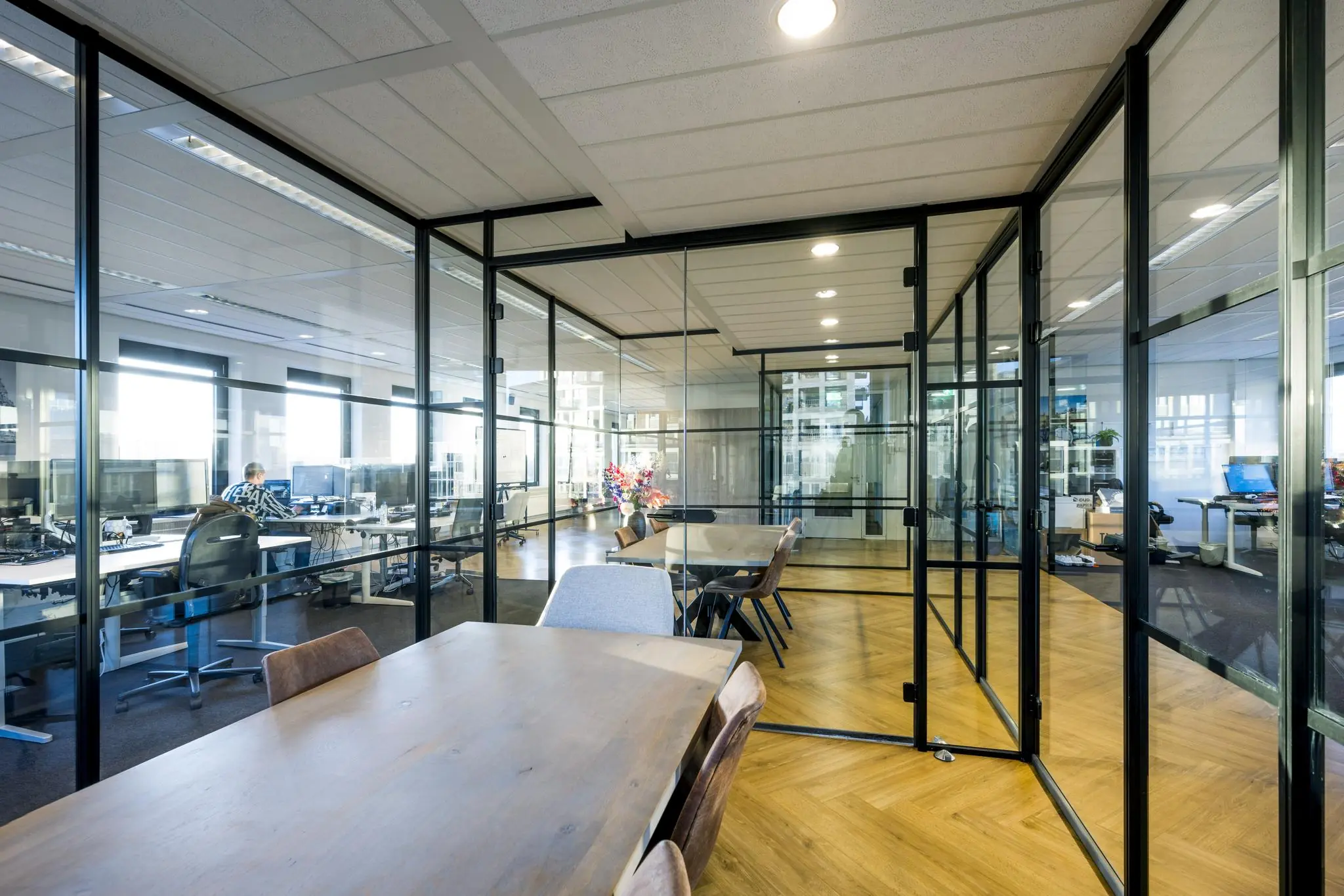 Moderne kantoorruimte aan de Radarweg met glazen vergaderruimtes en open werkplekken.