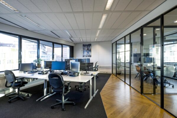 Modern kantoorinterieur aan de Radarweg met open werkplekken en vergaderruimtes met glazen wanden.