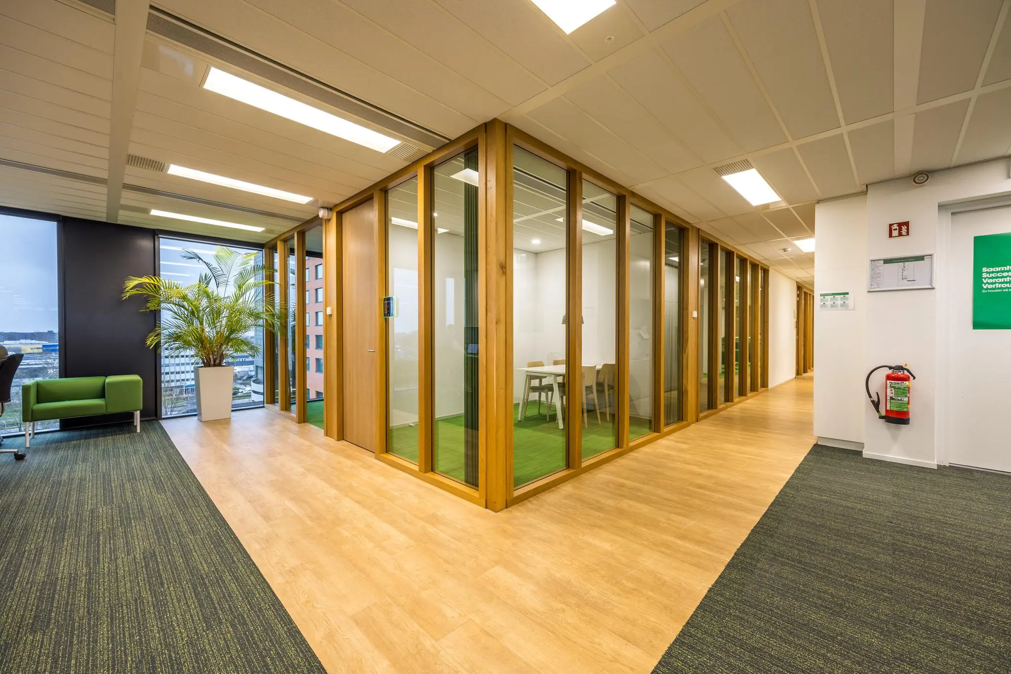 Moderne kantoorruimte aan de Winthontlaan met glazen vergaderruimtes, houten details en uitzicht op de stad.