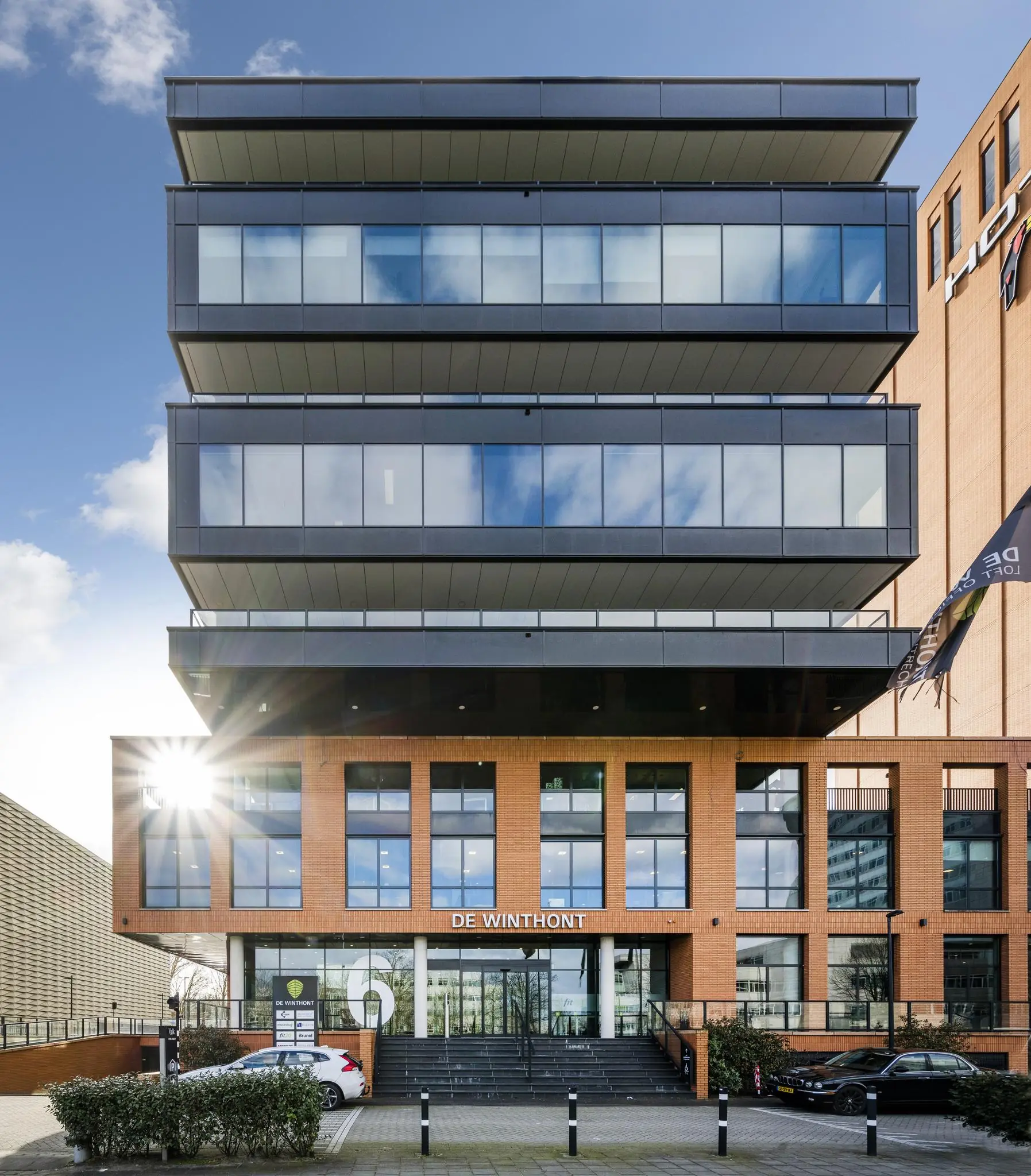 Voorgevel van kantoorgebouw De Winthont aan de Winthontlaan met moderne architectuur en zonlichtreflectie op de ramen.