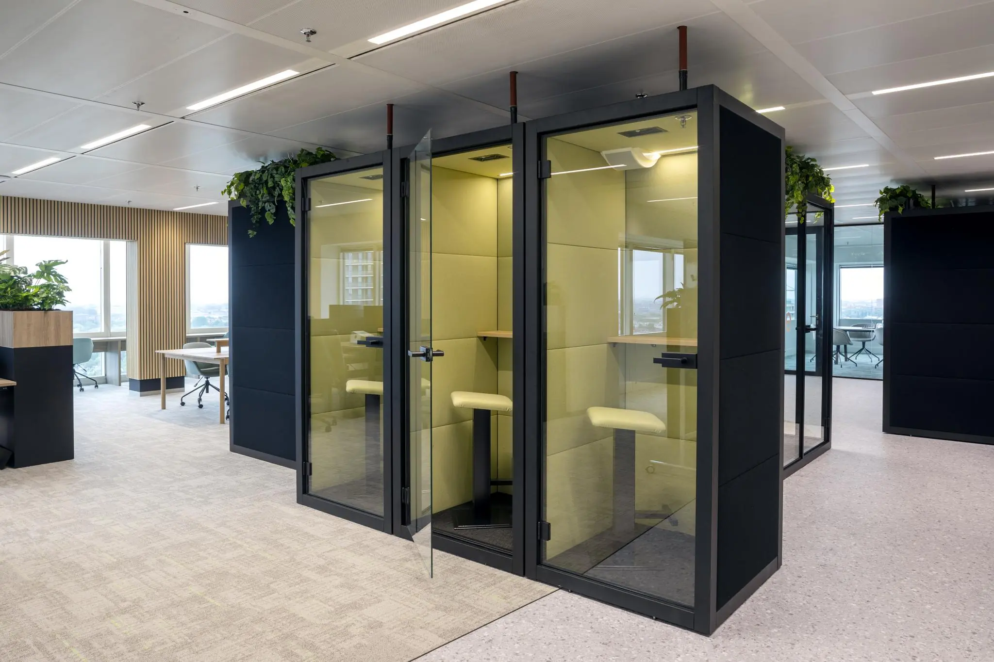 Moderne kantoortuin op Amstelplein met twee glazen belcellen en veel daglicht.