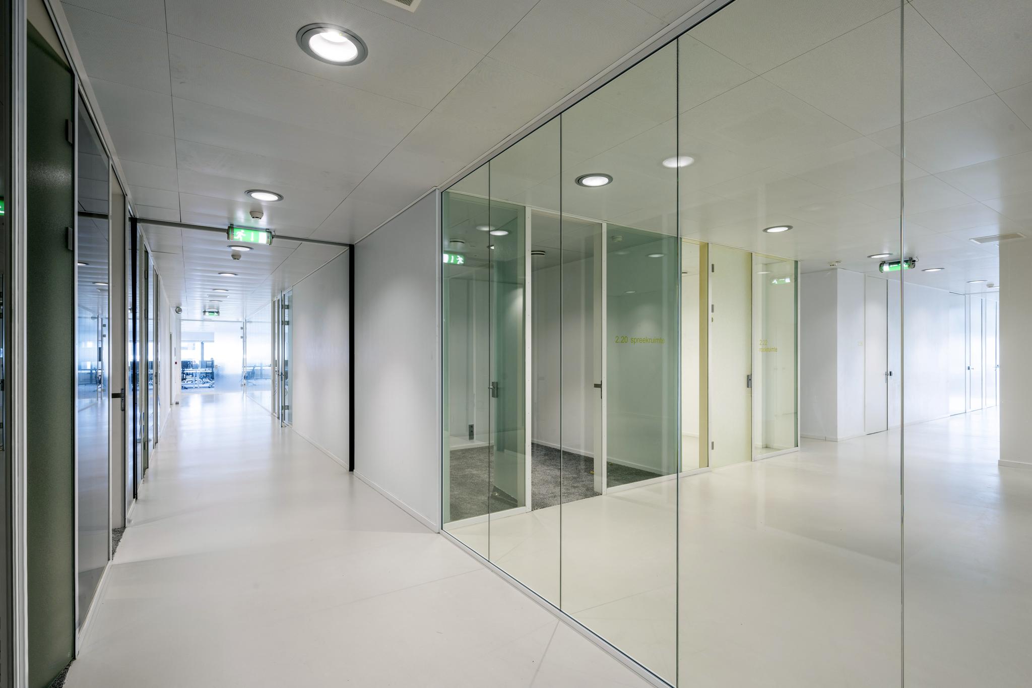 Moderne, lichte kantoorhal met glazen wanden en spreekkamers aan de Prof. E.M. Meijerslaan.