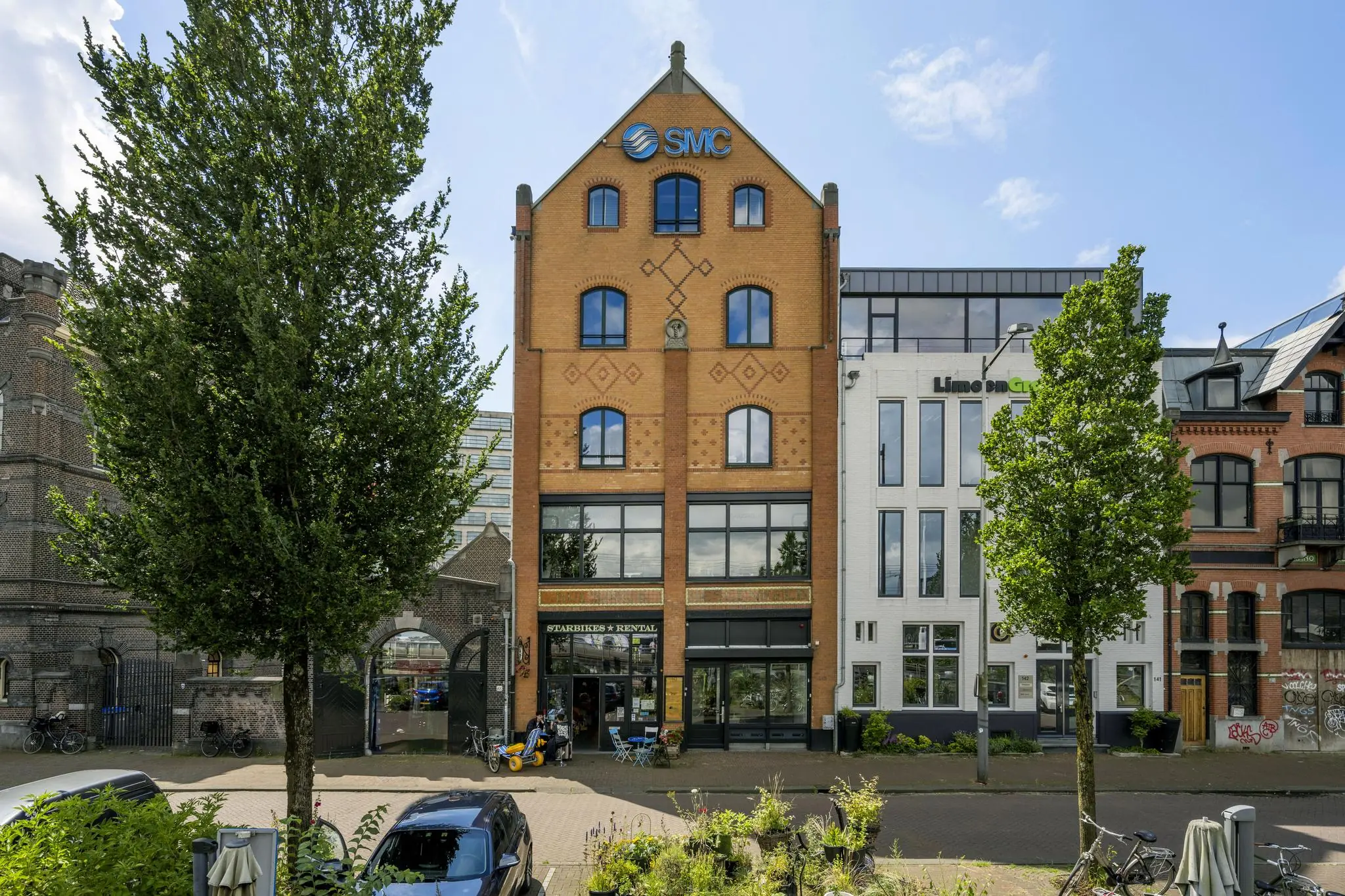 Voorgevel van een karakteristiek kantoorpand aan de De Ruijterkade in Amsterdam met het logo van SMC op de gevel.