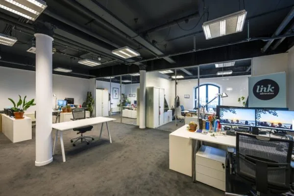 Modern kantoorinterieur van advocatenkantoor Link aan de De Ruijterkade met glazen wanden, bureaus en kantoormeubilair.