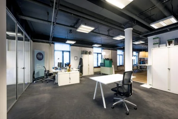 Modern kantoorinterieur aan de De Ruijterkade met bureaus, archiefkasten en industriële plafondafwerking.