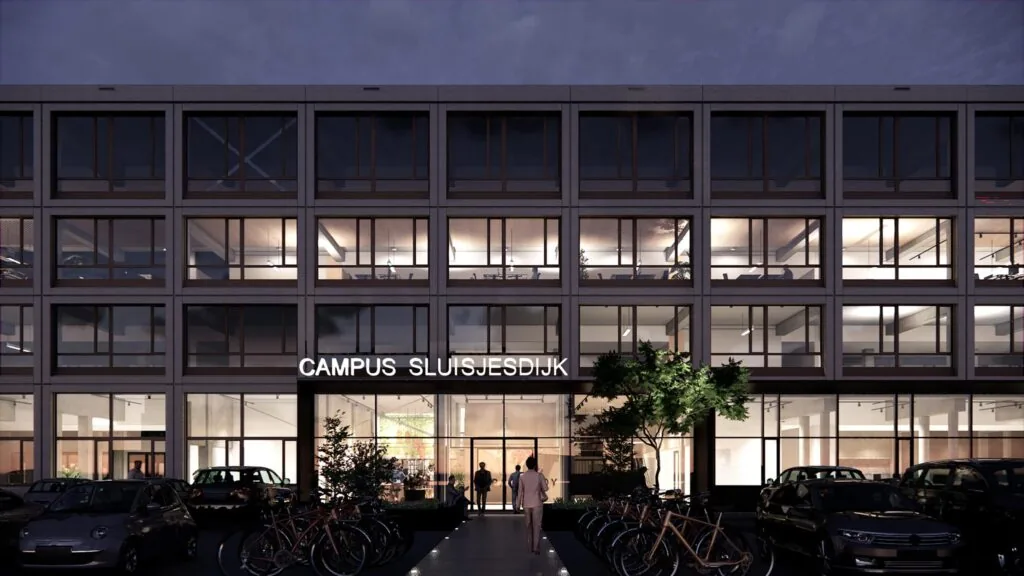 Avondaanzicht van de verlichte gevel van Campus Sluisjesdijk met fietsen en geparkeerde auto's ervoor.