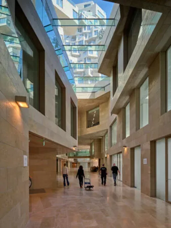 Moderne overdekte passage in het gebouw aan de Beethovenstraat, met glazen plafonds en natuurstenen wanden.