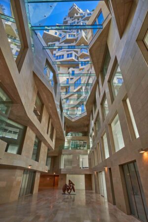 Moderne atriumruimte met glazen plafond en sculptuur in het gebouw aan de Beethovenstraat.