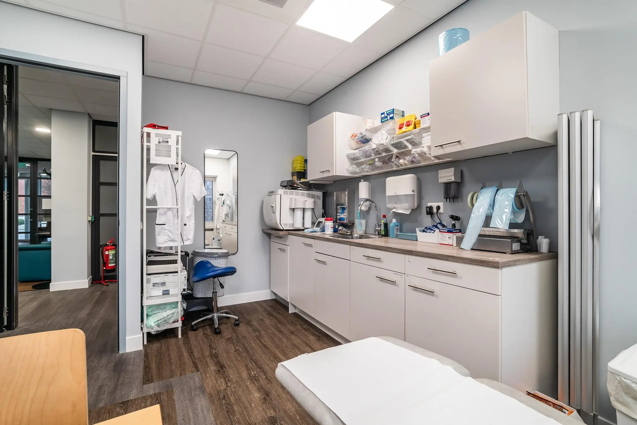 Moderne behandelkamer aan de Bordewijklaan met medische apparatuur, opbergkasten en een onderzoeksbank.
