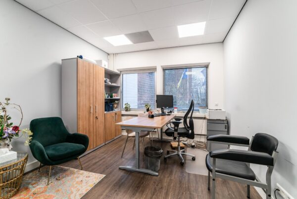 Modern kantoor aan de Bordewijklaan met houten meubels, bureau, computer en zitgelegenheid.