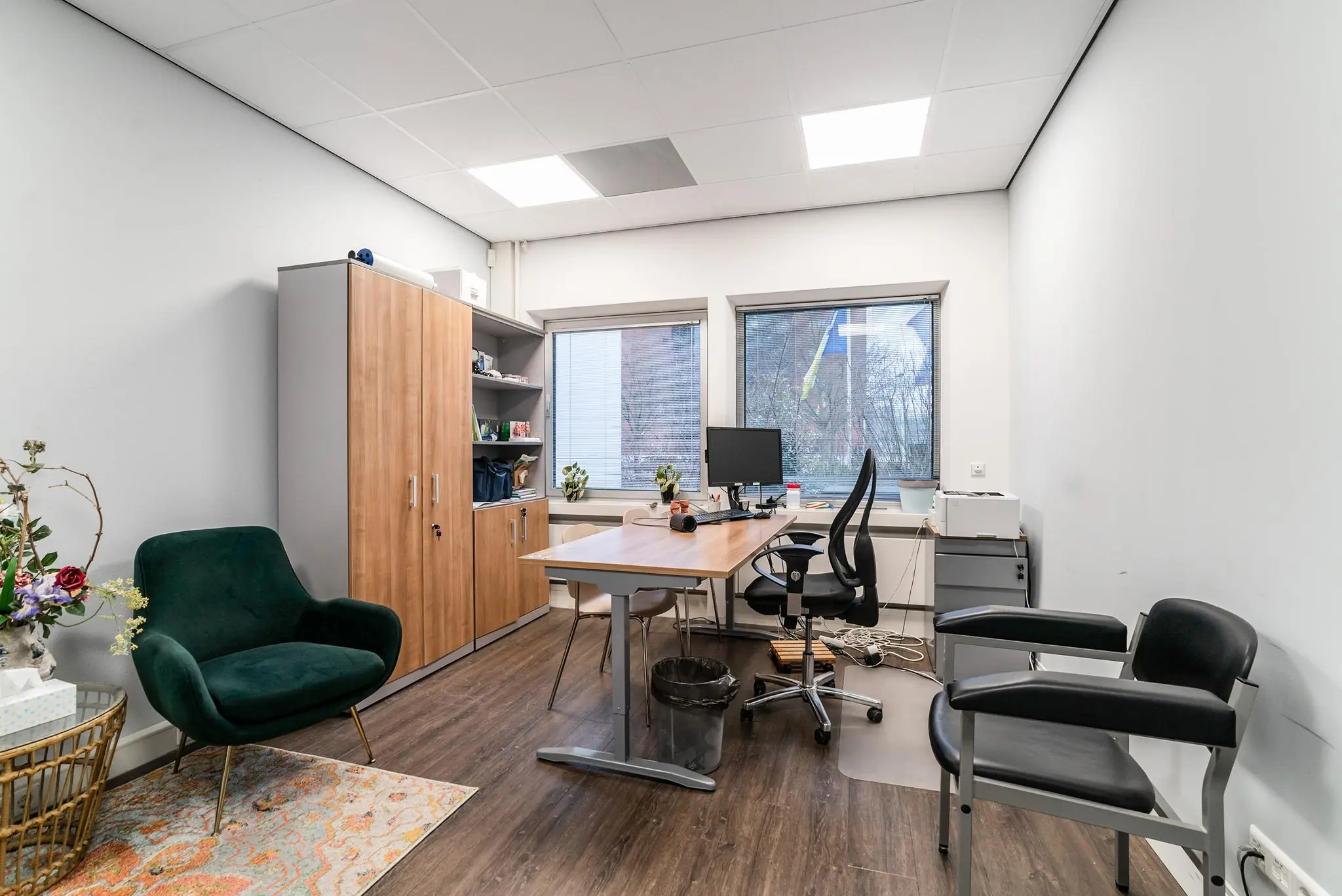 Modern kantoor aan de Bordewijklaan met houten meubels, bureau, computer en zitgelegenheid.