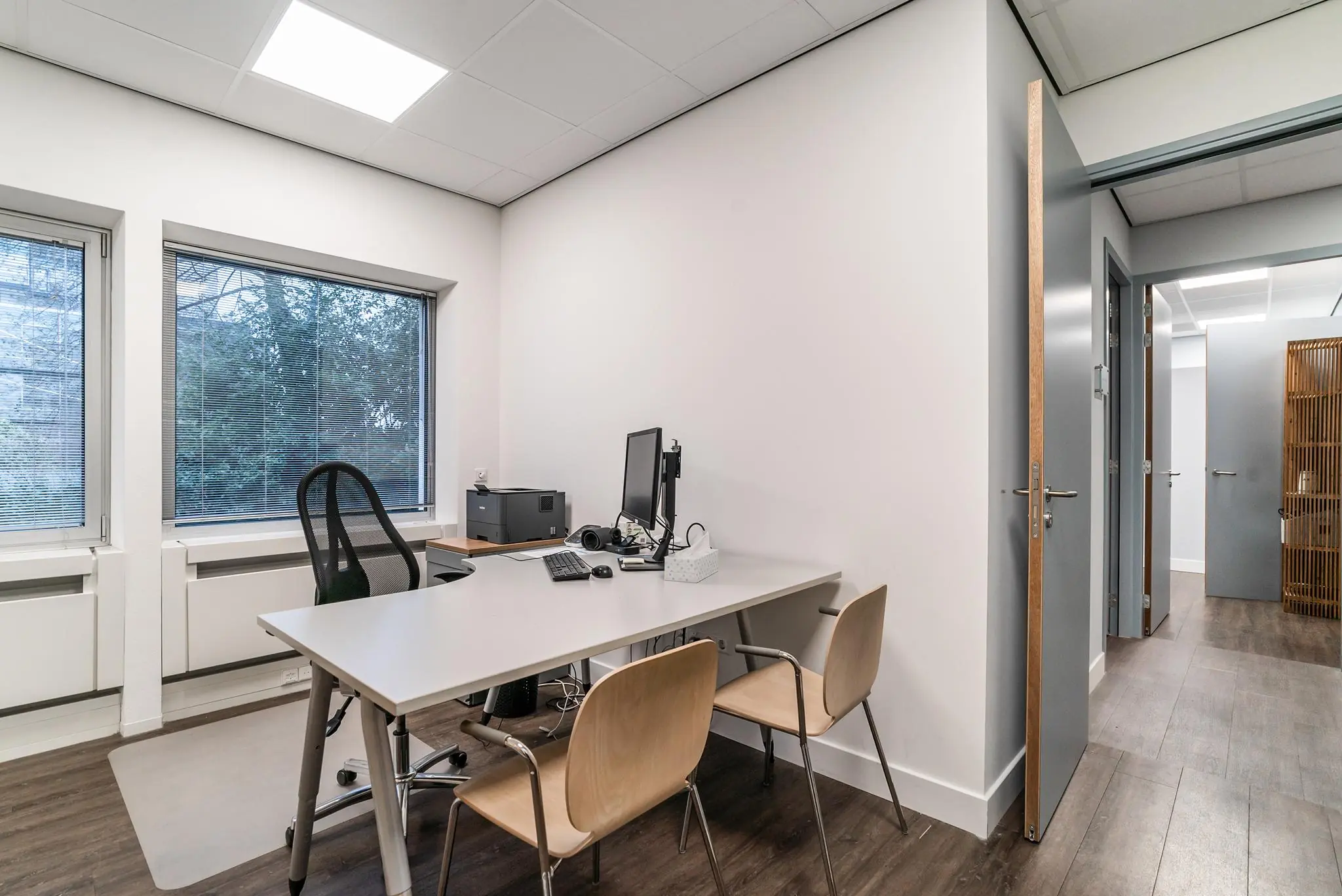 Modern en licht kantoorkamertje aan de Bordewijklaan met bureau, computer en drie stoelen.