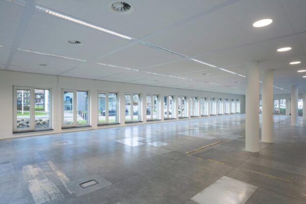 Leeg kantoorpand aan de De Cuserstraat met veel ramen en systeemplafond.