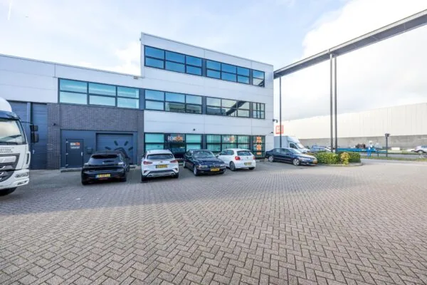 Bedrijfsgebouw aan de Atoomweg met meerdere geparkeerde auto's en het logo van Remeon op de gevel.