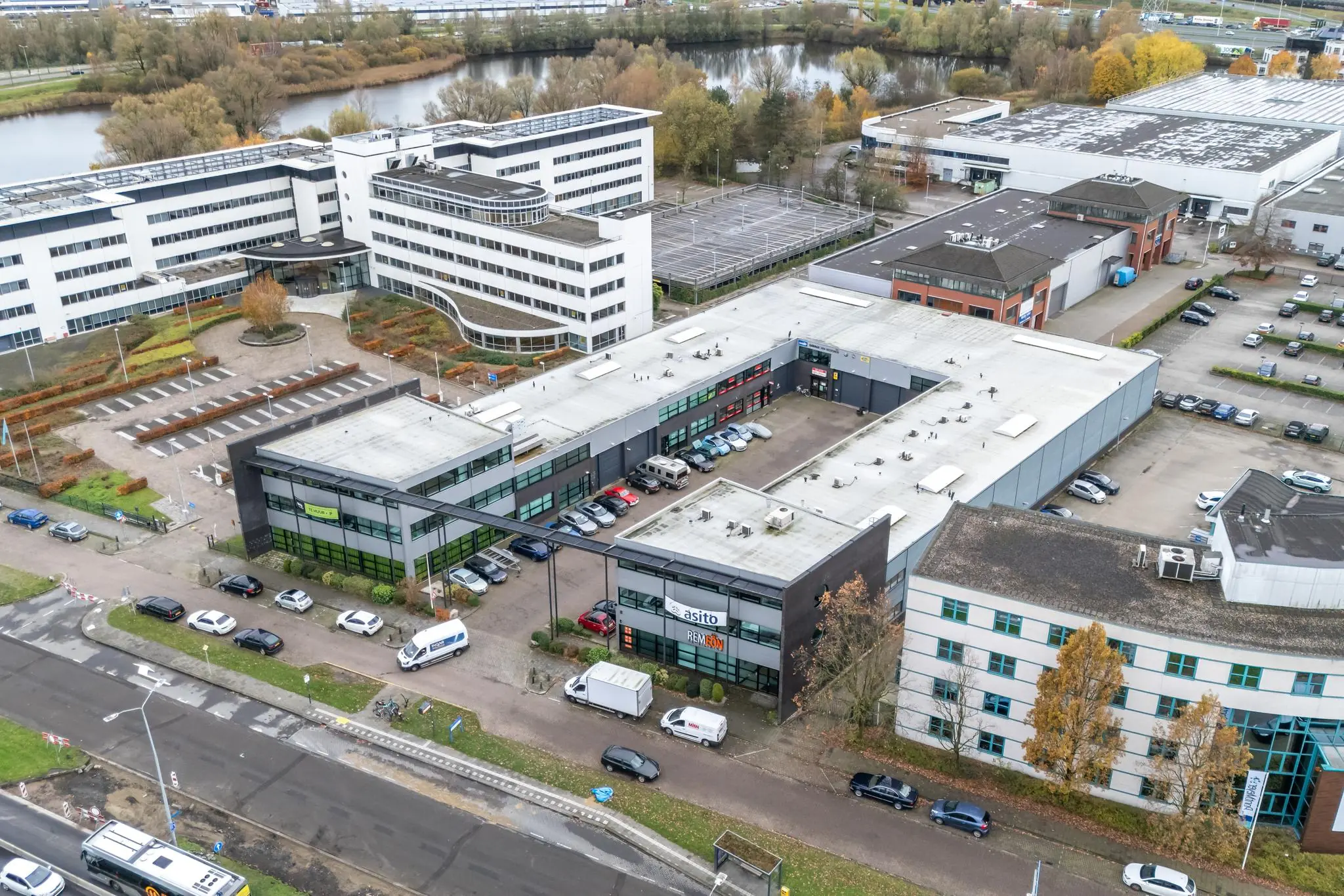 Luchtfoto van een bedrijfsverzamelgebouw aan de Atoomweg met parkeerplaatsen en omliggende kantoren.