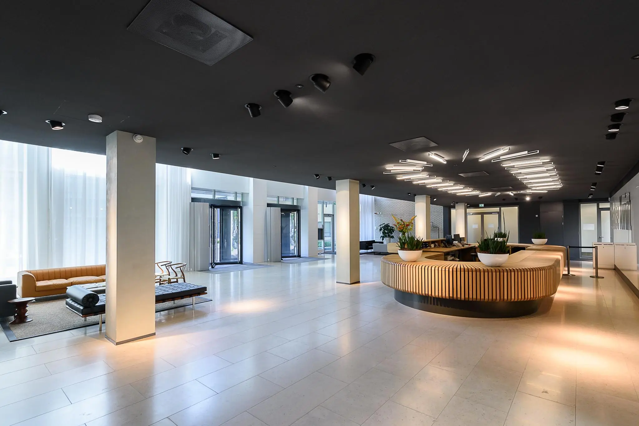 Modern ingerichte ontvangsthal van Daalseplein met een ronde houten balie, zitgedeelte en strakke verlichting.